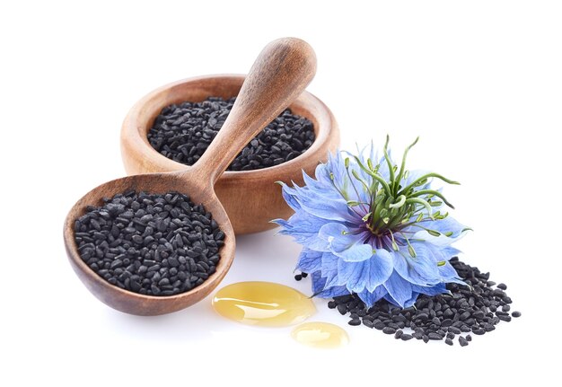 Black cumin seeds with nigella sativa flower on white background