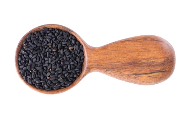 Black cumin seeds in wooden spoon isolated on white background Heap of black nigella seeds Nigella sativa Top view