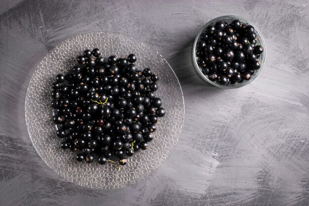 Black currant on gray table with leaf sprig