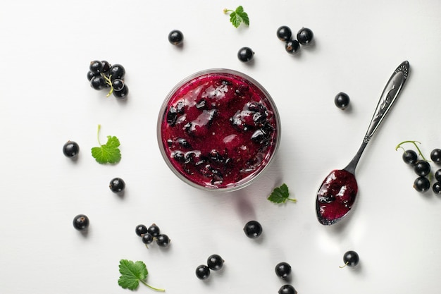 Black currant on wooden table with leaf sprig