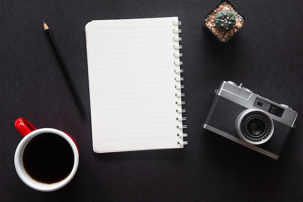 Black desk office with laptop, smartphone and other work
supplies with cup of coffee. top view with copy space for input the
text. designer workspace on desk table essential elements on flat
lay.