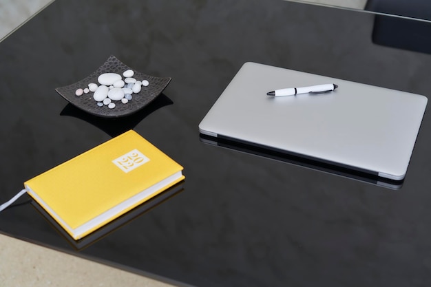 Black desk with laptop and yellow schedule