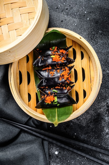 Black Dim sum dumplings in bamboo steamer. Asian cuisine