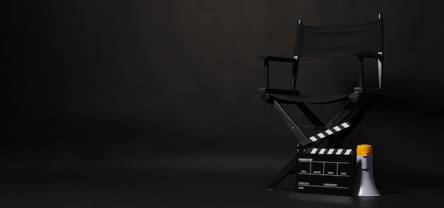 Black director chair and Clapper board or movie Clapperboard with megaphone on black background.use in video production or film cinema industry