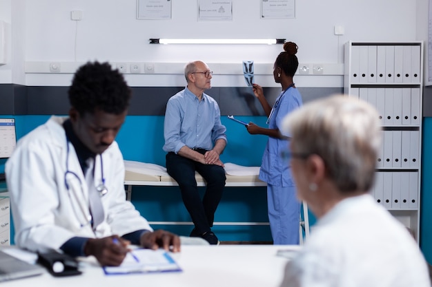 Photo black doctor consulting elder patient sitting at desk