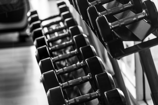 Photo black dumbbell set close up many metal dumbbells on rack in sport fitness center  weight training