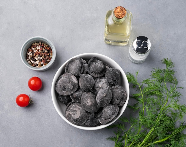 Black dumplings with meat herbs and spices on a gray background russian seberian tradition food