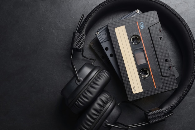 Black on-ear headphones and audio tape compact cassettes