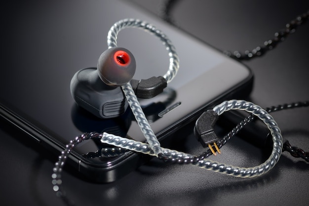 Black earbuds and smartphone