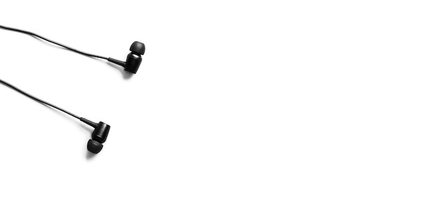 Photo black earphones lying on the white background. modern music concept. audio technology.