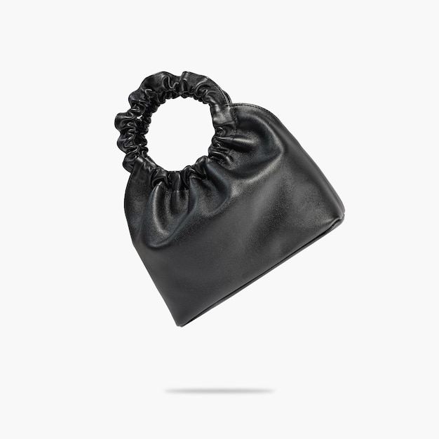 A black ecoleather bag floats on a gray background A creative composition of a levitating handbag A conceptual composition of fashionable women's accessories Handmade ecofriendly leather bag