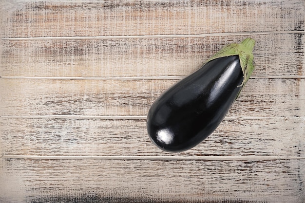 black eggplant on a wooden background - top view - copyspace