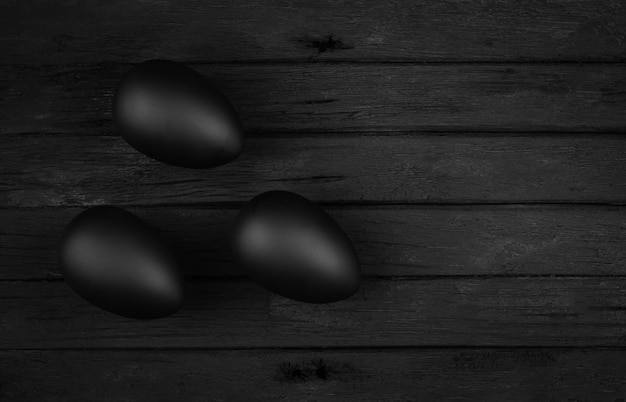 Black eggs on a wooden background