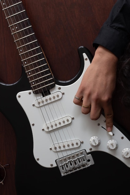 검은색 일렉트릭 기타와 기타에 음악가의 손, 기타리스트는 손가락에 반지를 끼고 있습니다.