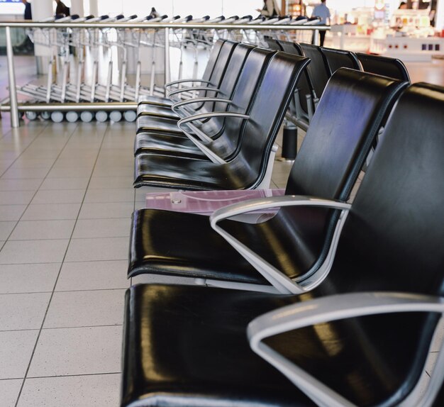 black empty chairs in public area near gate in airport