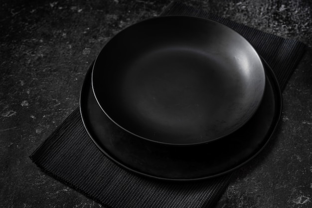 A black empty plate on black background