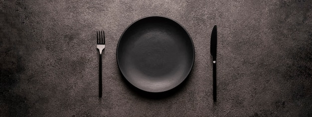 black empty plate and cutlery, fork and knife