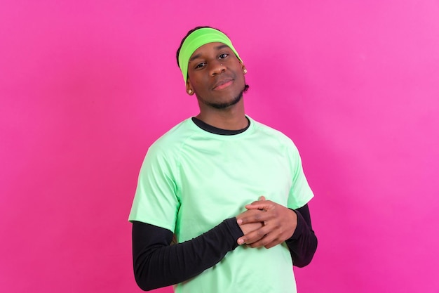 Black ethnic man in green clothes on a pink background concept portrait