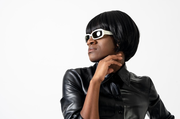 Black ethnic man in studio with white background LGTBI concept wearing leather and looking to the left