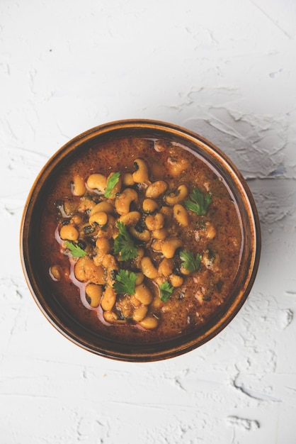 Black Eyed Kidney Beans Curry or Chawli or chavli chi usal or masala, served in a ceramic bowl over moody background, selective focus