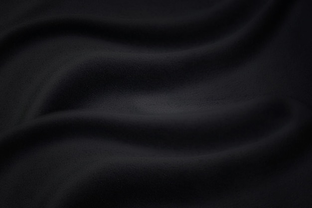 Photo black fabric texture background, wavy fabric slippery black color, luxury satin or silk cloth texture.