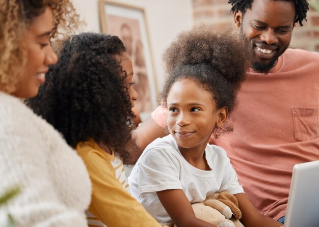 Black family kids and laptop for education gaming or streaming on sofa of living room in home together Computer smile and parents with girl kids in apartment for homework research or study