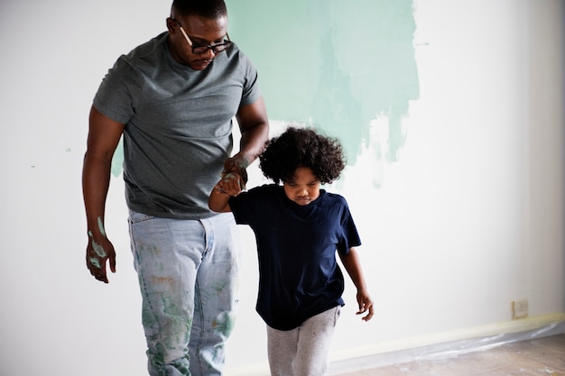 Black family painting house wall