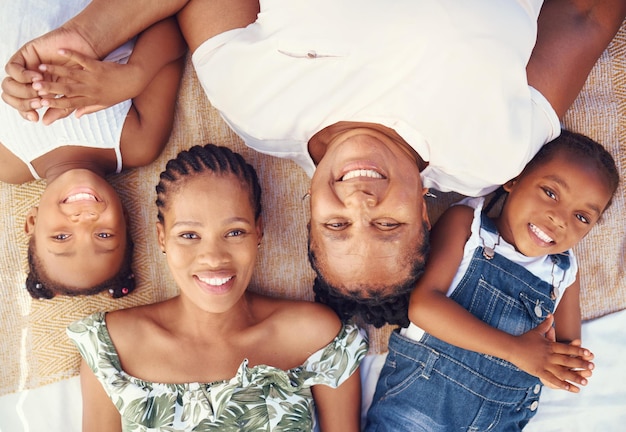 Black family portrait with mother grandma and children relax for summer vacation holiday or happy break in sunshine Big family and kids face smile together lying on ground at beach from above
