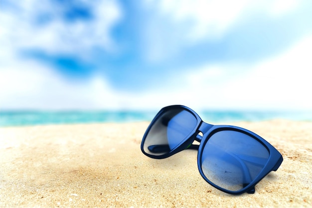 Black fashion sunglasses on sand beach