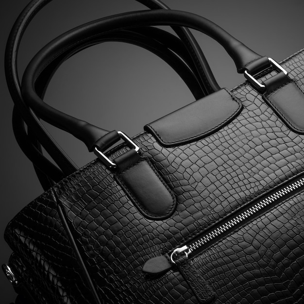 Черная модная дизайнерская женская сумка на темном фоне