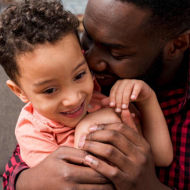 Black father hugging cute son 