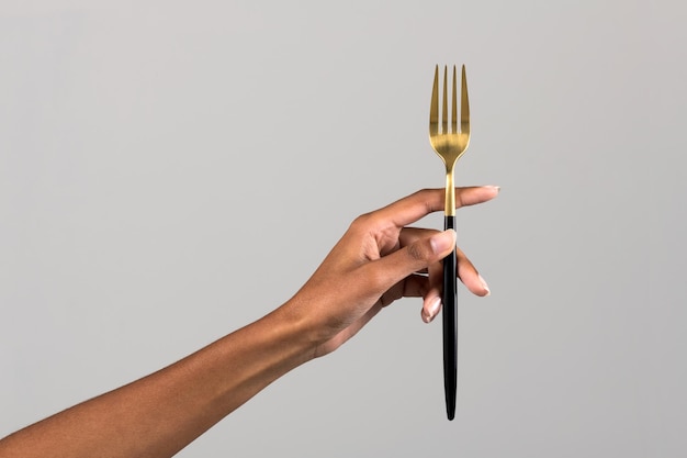 Black female hand showing fork