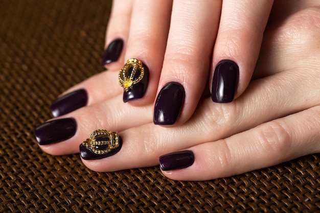 Black female manicure nails closeup with crown.