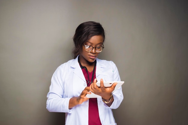 Black female nurse holding tablet devices checking\
internet