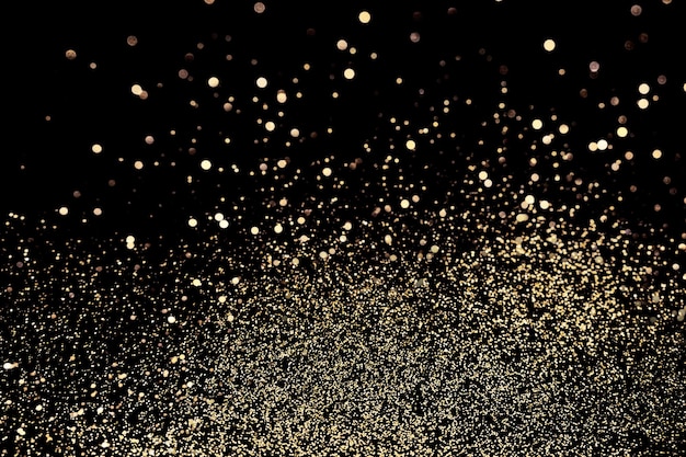 Photo black festive background abstract scattering of gold sparkles on black christmas backdrop selective focus