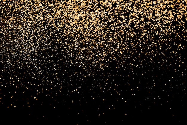 Black festive background of golden glitter lights Holiday backdrop selective focus