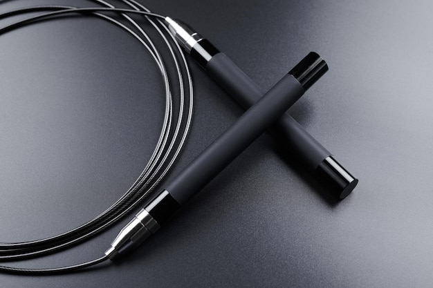 Black fitness skipping rope closeup on black background sports equipment