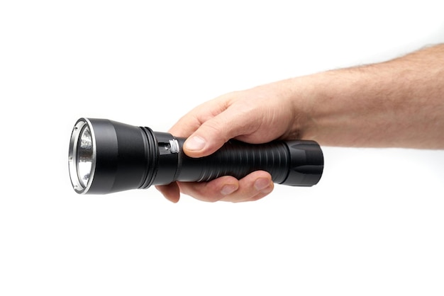 Photo black flashlight in hand on a white background