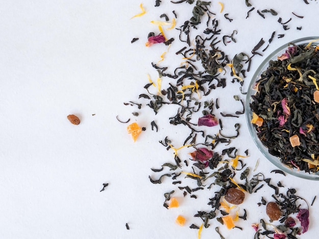 Black flavored tea in a glass jar and scattered on the table top view Tea shop concept