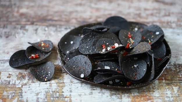 Black food Black chips with spices on a plate