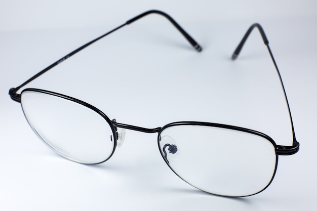 Black frame glasses on a white background. Close up photo.