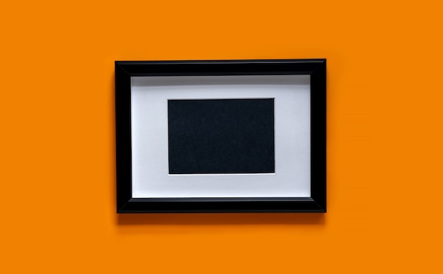 Black frame on orange background . flat lay, top view