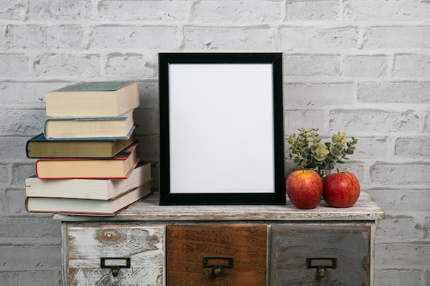 Black frame in vertical mock up with books and leaves