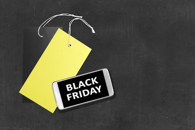 Black Friday-bericht op het scherm van de mobiele telefoon met labeltag op zwarte achtergrond. Black Friday-concept