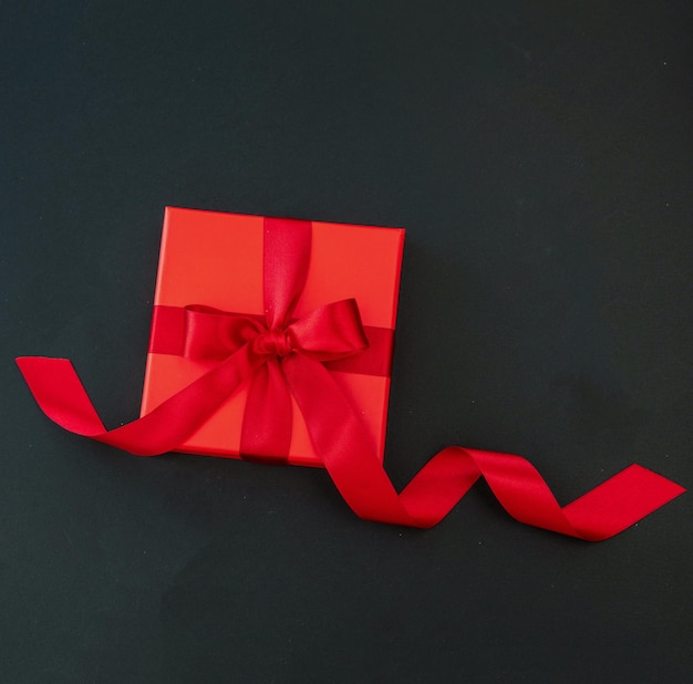 Black friday birthday valentines day red gift box red ribbon on\
black background top view space