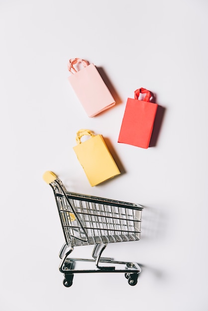 Photo black friday composition with three bags and cart