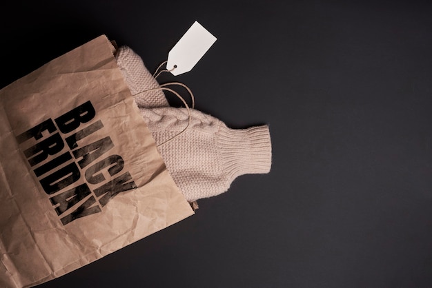 Фото Черная пятница концепт теплый вязаный свитер в сумке для покупок зимней одежды, приобретенной в черном цвете ...