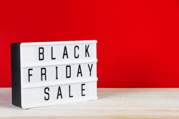 Foto black friday-concept. teken op een rode achtergrond. plaats voor tekst.