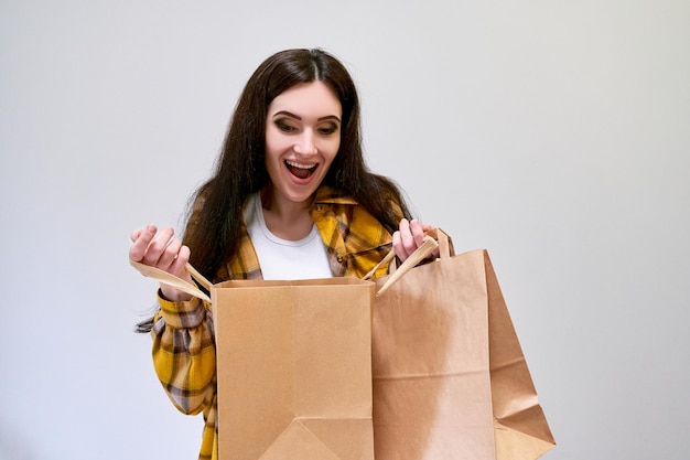 Foto black friday-concept verraste vrouw met papieren boodschappentassen en geniet van winkelen