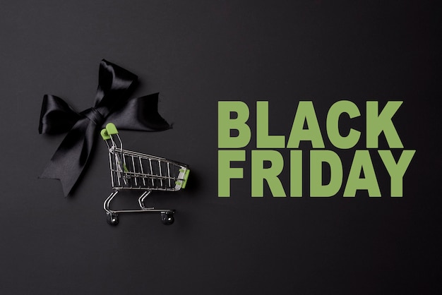 Photo black friday concept with shopping trolley on black background